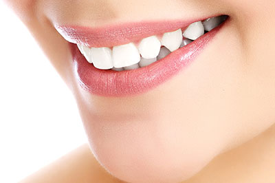 The image shows a close-up view of a smiling person with a focus on their teeth and lips, highlighting dental hygiene and cosmetic enhancement.